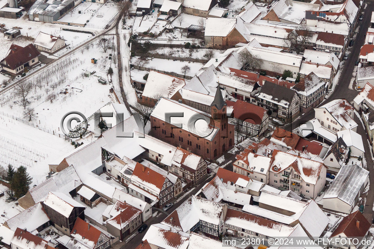 Vue aérienne de Église protestante hivernale et enneigée au centre du village à Steinweiler dans le département Rhénanie-Palatinat, Allemagne