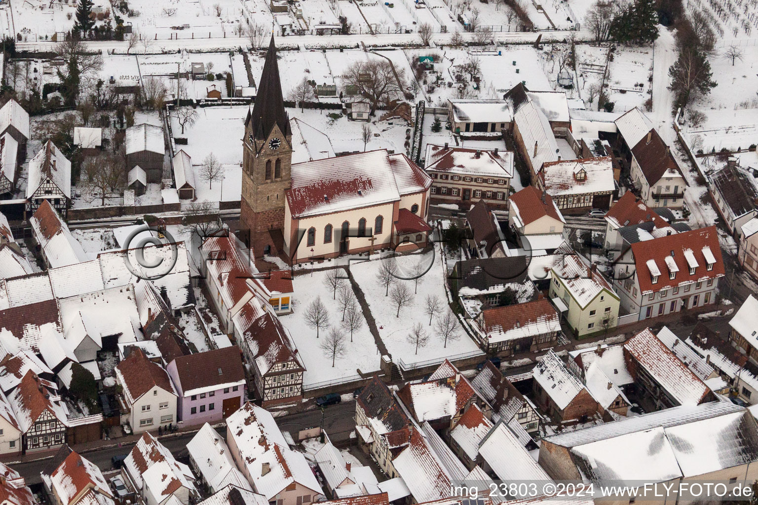 Vue aérienne de Église catholique enneigée en hiver au centre du village à Steinweiler dans le département Rhénanie-Palatinat, Allemagne