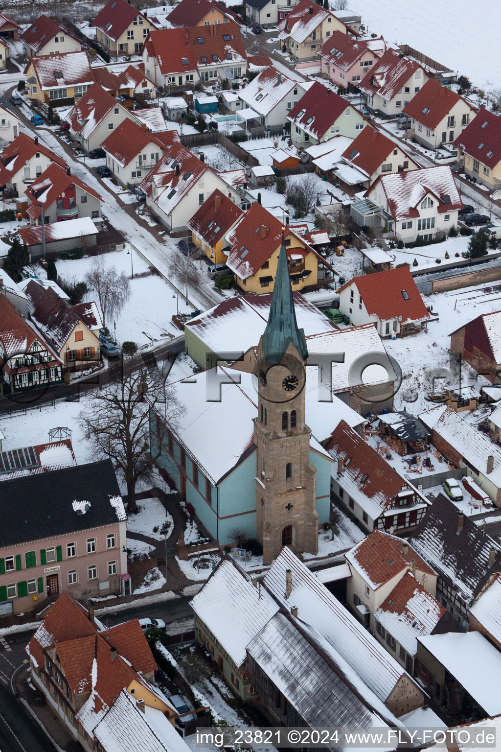 Vue aérienne de Bâtiments d'église enneigés en hiver au centre du village à Erlenbach bei Kandel dans le département Rhénanie-Palatinat, Allemagne