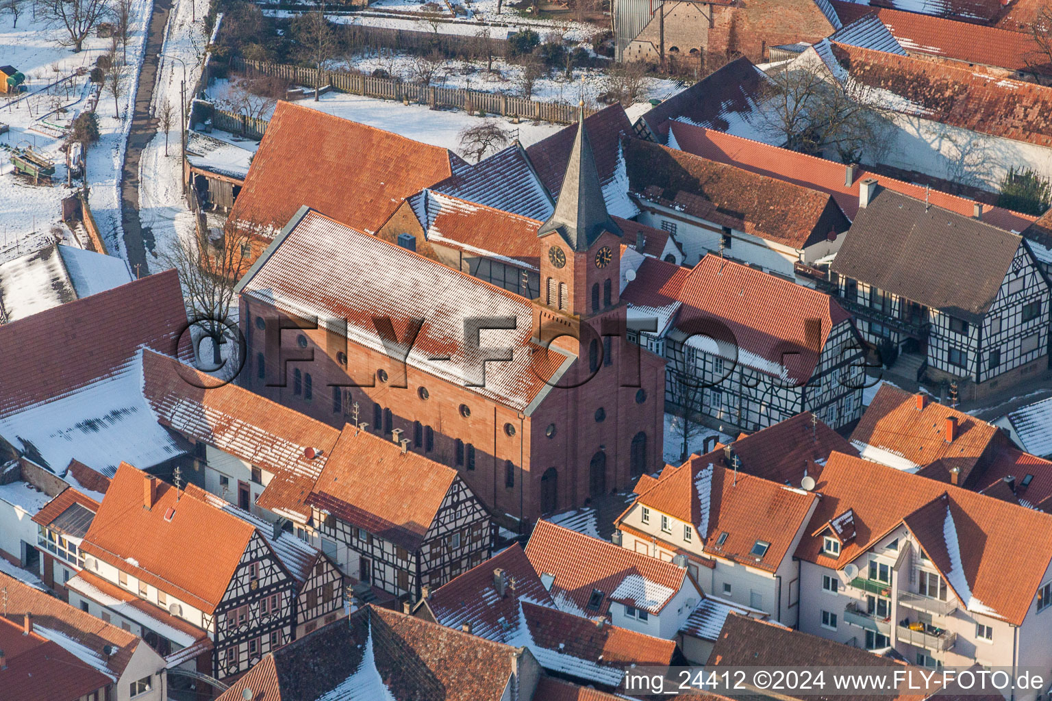 Vue aérienne de Église protestante hivernale et enneigée au centre du village à Steinweiler dans le département Rhénanie-Palatinat, Allemagne