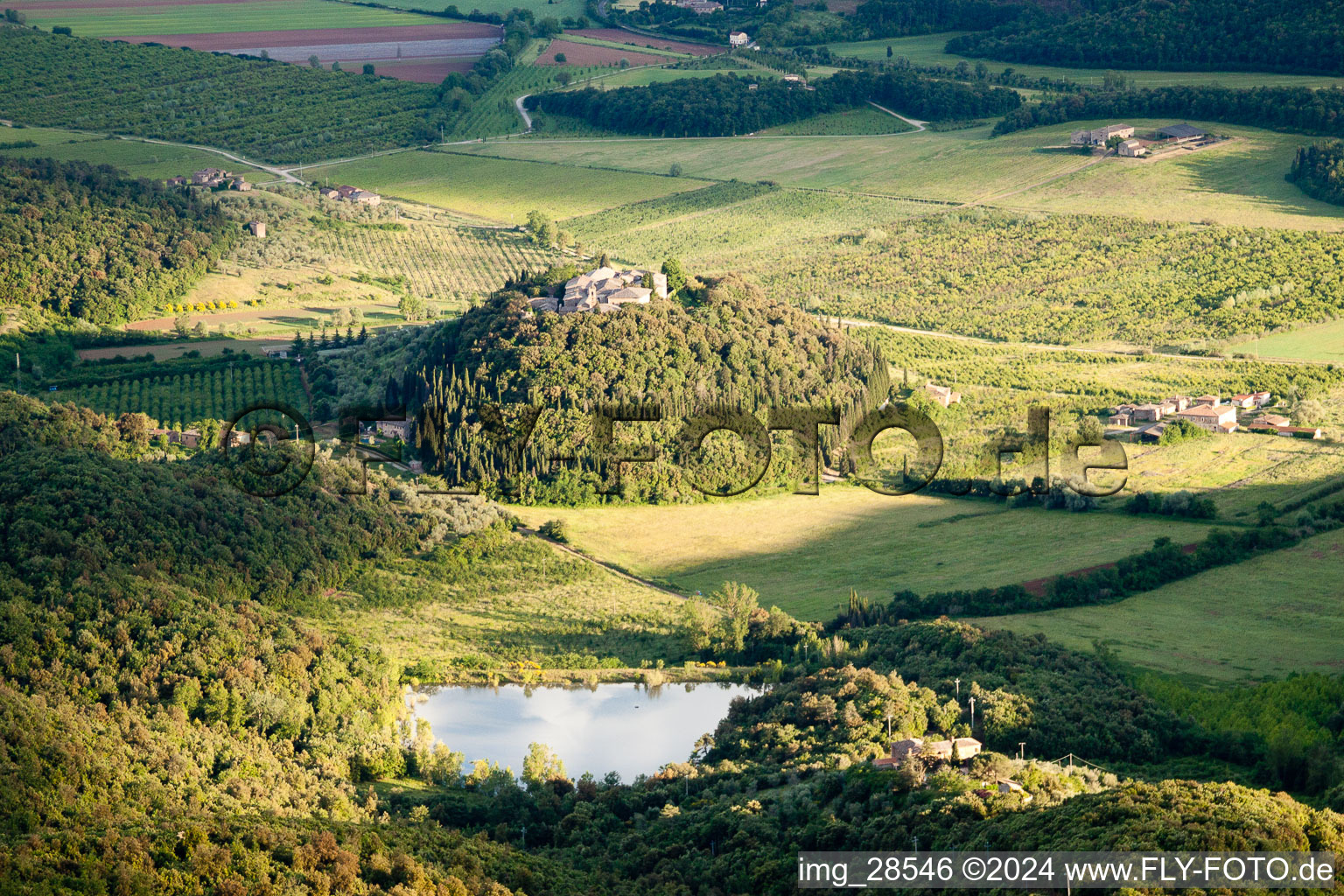 Vue aérienne de Sur une colline ronde et boisée avec un lac à Poggio Santa Cecilia dans le département Toscane, Italie
