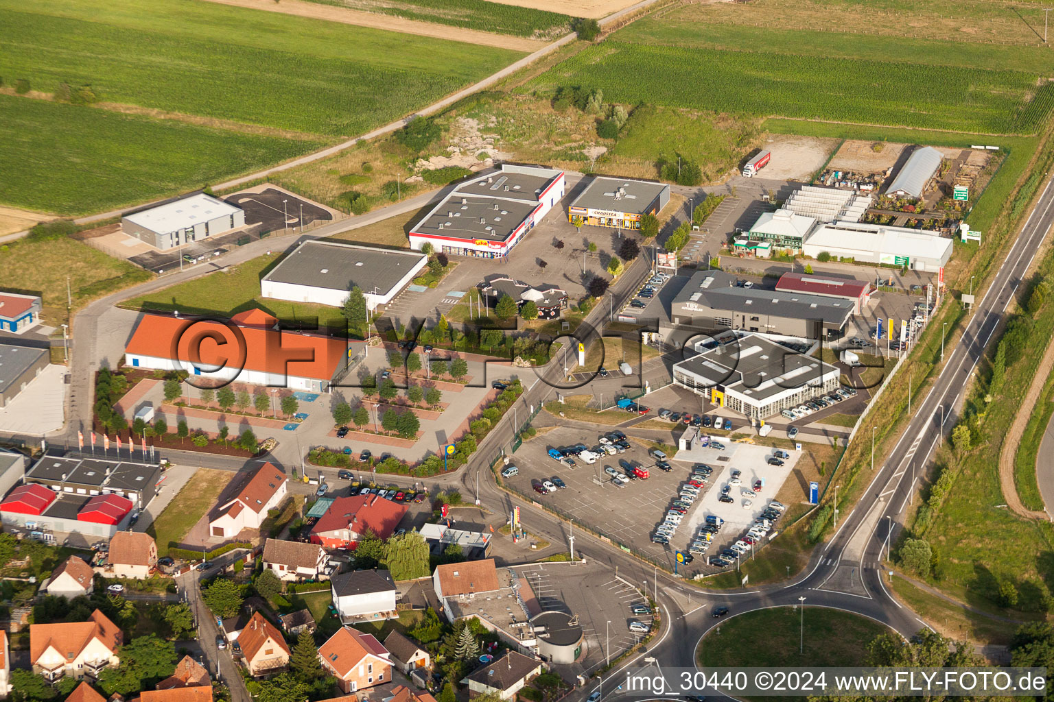 Vue aérienne de Zone commerciale et implantation d'entreprises rue des Champs à Oberhoffen-sur-Moder dans le département Bas Rhin, France