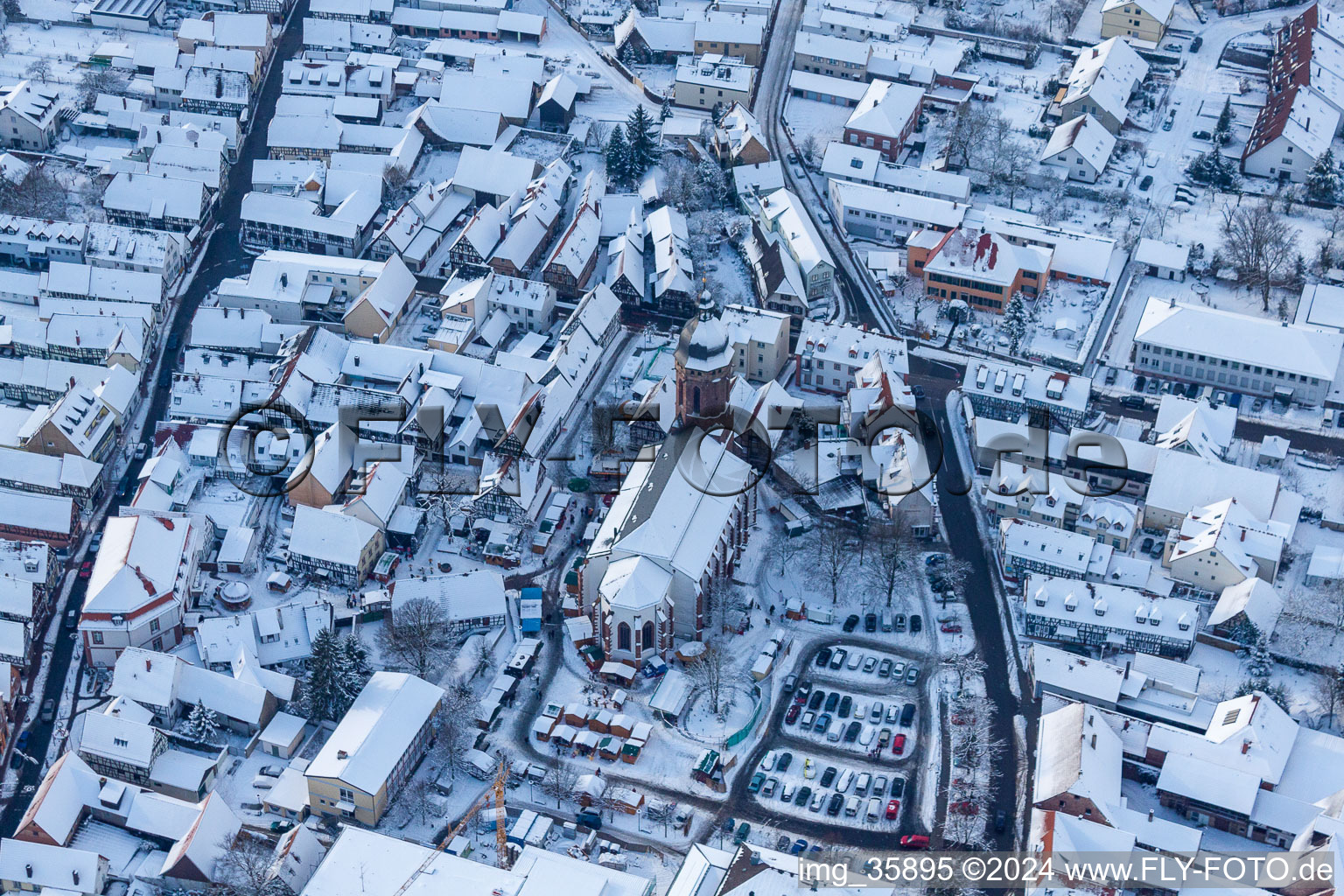 Vue aérienne de Vue aérienne hivernale de la zone événementielle du marché de Noël "Kandeler Christkindl-Markt" et des cabanes de vente et des étals sur la place du marché autour de l'église Saint-Georges à Kandel dans le département Rhénanie-Palatinat, Allemagne