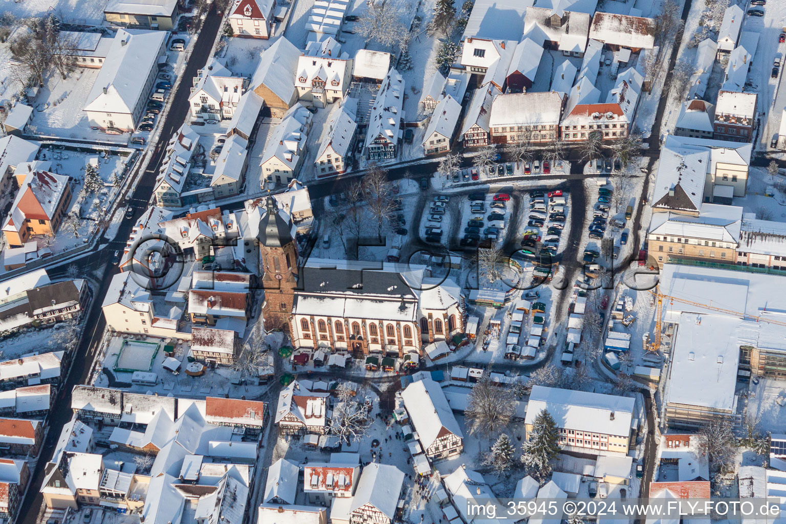 Vue aérienne de Vue aérienne hivernale de la zone événementielle du marché de Noël "Kandeler Christkindl-Markt" et des cabanes de vente et des étals sur la place du marché autour de l'église Saint-Georges à Kandel dans le département Rhénanie-Palatinat, Allemagne