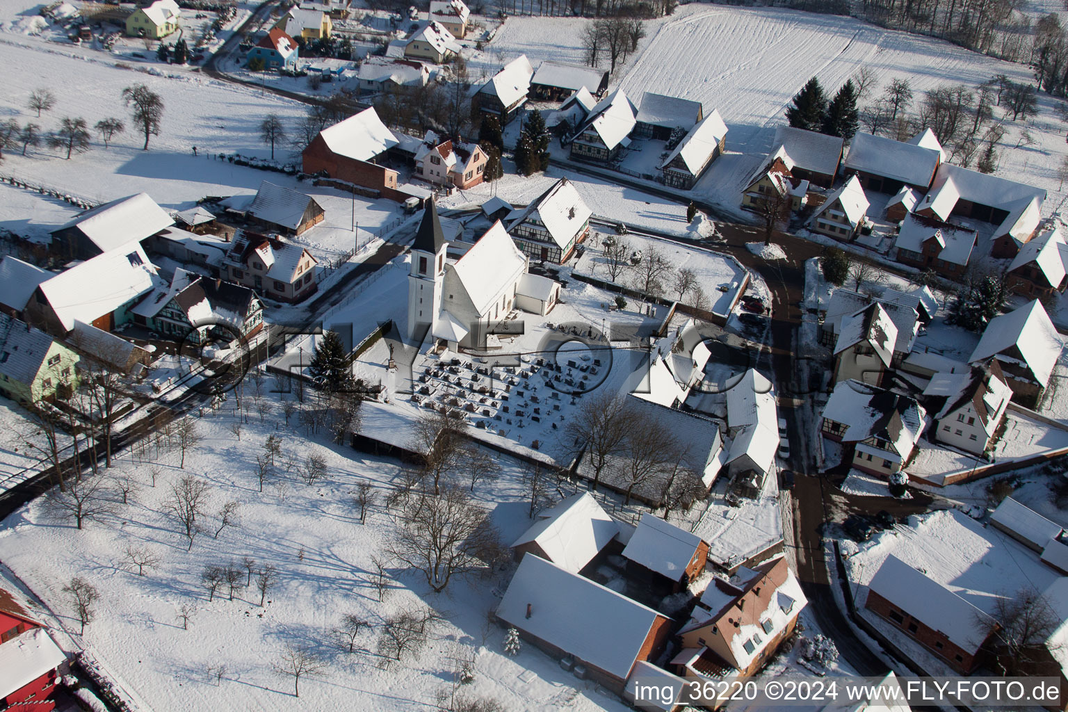 Vue oblique de Bâtiments d'église enneigés en hiver au centre du village à Eberbach-Seltz dans le département Bas Rhin, France