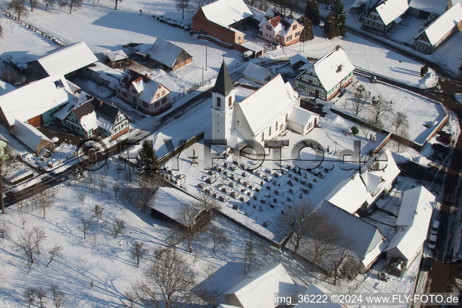 Bâtiments d'église enneigés en hiver au centre du village à Eberbach-Seltz dans le département Bas Rhin, France d'en haut