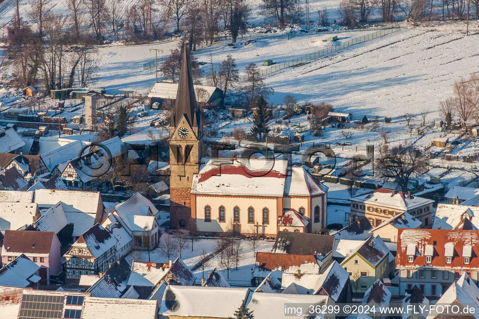 Photographie aérienne de Église catholique enneigée en hiver au centre du village à Steinweiler dans le département Rhénanie-Palatinat, Allemagne