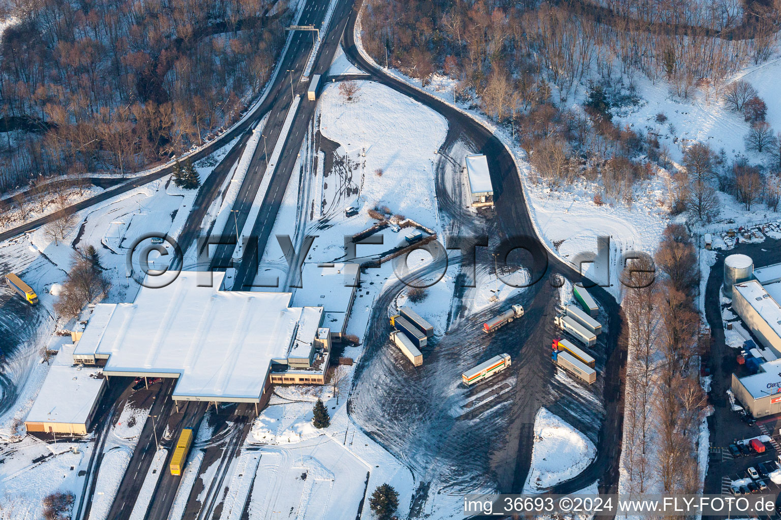 Vue aérienne de L'hiver, parkings pour camions enneigés et entrepôts en plein air à l'ancien poste frontière de Lauterbourg, aujourd'hui commissariat fédéral de la police fédérale de Bienwald à Scheibenhard dans le département Bas Rhin, France