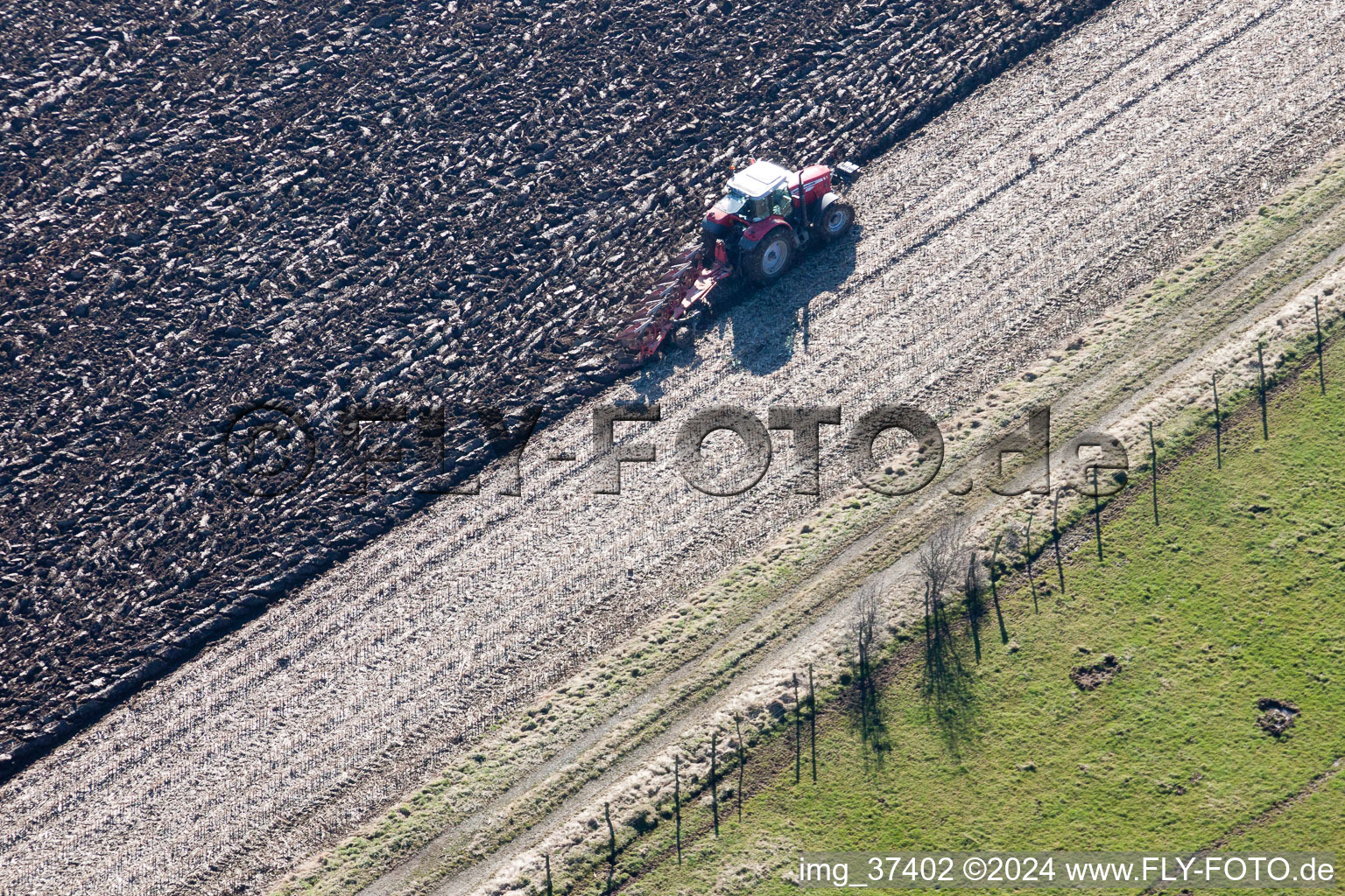 Vue aérienne de Travaux de labour et déplacement de la terre par un tracteur avec une charrue sur les champs agricoles à Lampertsloch dans le département Bas Rhin, France