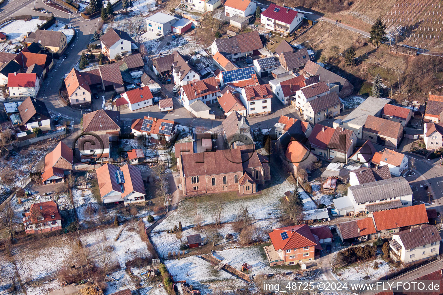 Vue aérienne de Bâtiments d'église enneigés en hiver au centre du village à le quartier Neuenbürg in Kraichtal dans le département Bade-Wurtemberg, Allemagne