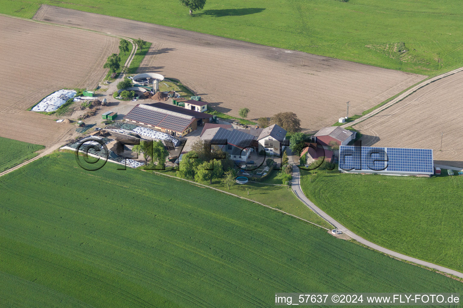 Vue aérienne de Corps de ferme aux toits photovoltaïques en bordure de champs cultivés à le quartier Liggersdorf in Hohenfels dans le département Bade-Wurtemberg, Allemagne