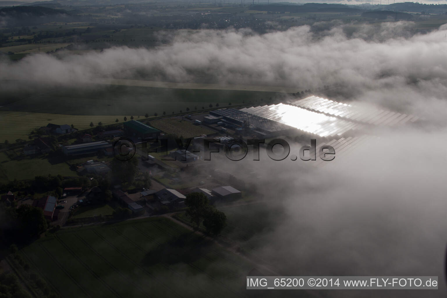 Vue aérienne de En raison des conditions météorologiques, les rangées de panneaux du système photovoltaïque du parc solaire ou de la centrale solaire du quartier de Bredenborn sont noyées dans une couche de brouillard. à Marienmünster dans le département Rhénanie du Nord-Westphalie, Allemagne