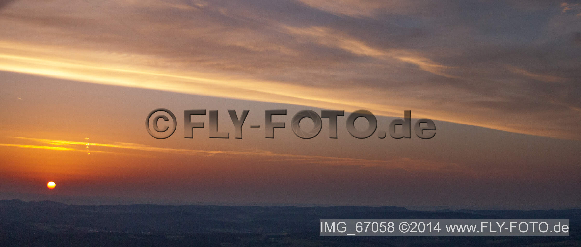 Vue aérienne de Le coucher du soleil rend le ciel sur le paysage rouge-orange à Ehingen (Donau) dans le département Bade-Wurtemberg, Allemagne