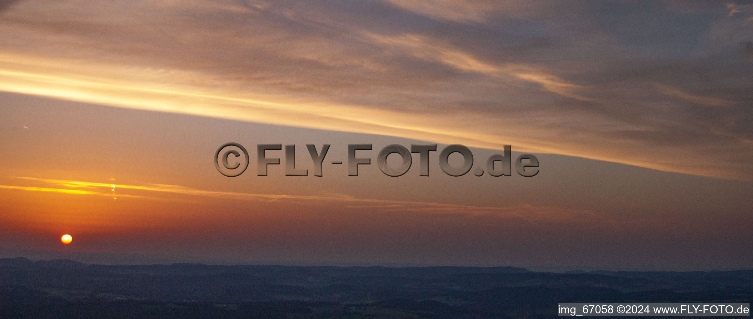 Vue aérienne de Le coucher du soleil transforme le ciel sur le paysage d'Ehingen (Donau) rouge orange à le quartier Kochstetten in Hayingen dans le département Bade-Wurtemberg, Allemagne