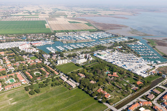 Vue aérienne de Port de plaisance avec amarrages et postes d'amarrage sur la rive de Marina Punta Gabbiani Aprilia Marittima dans le district d'Aprilia Marittima à Bevazzana à le quartier Località Aprilia Marittima in Marano Lagunare dans le département Udine, Italie