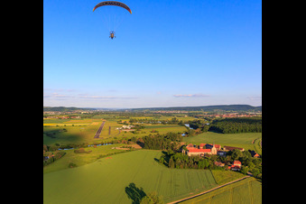 Vue aérienne de Parapente au-dessus du domaine Mariaburghausen avec l'église Saint-Jean-Baptiste Mariaburghausen à le quartier Mariaburghausen in Haßfurt dans le département Bavière, Allemagne