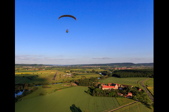 Vue aérienne de Parapente au-dessus du domaine Mariaburghausen avec l'église Saint-Jean-Baptiste Mariaburghausen à le quartier Mariaburghausen in Haßfurt dans le département Bavière, Allemagne