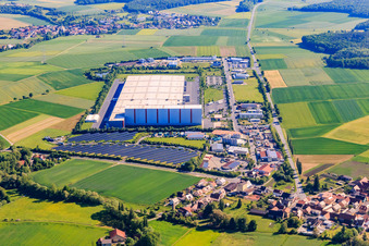 Vue aérienne de Zone industrielle Am Rödertor derrière une centrale photovoltaïque en plein air avec entrepôt central DLZ Donnersdorf et Kaufland Logistik VZ GmbH & Co. KG et Baumann Recycling GmbH à Donnersdorf dans le département Bavière, Allemagne