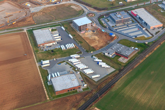 Photographie aérienne de Zone industrielle dans la vallée de Spire avec TRANSAC International Speditionsgesellschaft mbH, Markthalle 5, et le chantier de construction du nouveau bâtiment de Kardex Software GmbH à Rülzheim dans le département Rhénanie-Palatinat, Allemagne