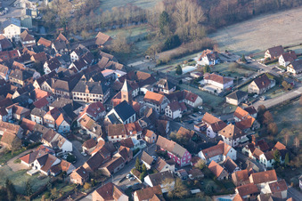 Vue aérienne de Église fortifiée luthérienne-protestante entourée d'un anneau de maisons au centre du village à Dossenheim-sur-Zinsel dans le département Bas Rhin, France