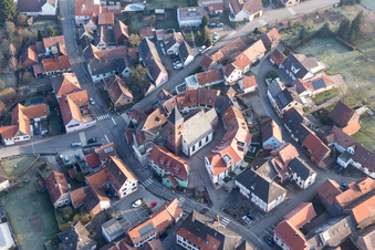 Image drone de Église fortifiée luthérienne-protestante entourée d'un anneau de maisons au centre du village à Dossenheim-sur-Zinsel dans le département Bas Rhin, France