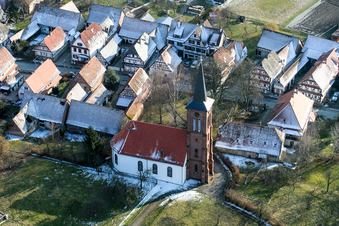 Vue aérienne de Église protestante de Hunspach enneigée en hiver au centre du village à Hunspach dans le département Bas Rhin, France
