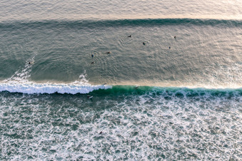 Wave surfeurs devant la Plage de Tronoën à Saint-Jean-Trolimon dans le département Finistère, France vu d'un drone