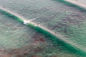 Vue aérienne de Surfeurs devant la plage la Torche-Tronoën à Saint-Jean-Trolimon dans le département Finistère, France