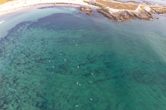 Vue aérienne de Surfeurs attendant la vague devant la plage la Torche-Tronoën à Plomeur dans le département Finistère, France