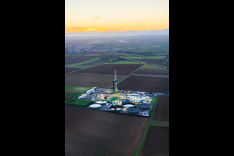 Vue aérienne de Le site de forage profond V20 de Vulcan Energy à Schleidberg, baigné par la lumière du soir, pour l'extraction d'énergie géothermique et de lithium. à Insheim dans le département Rhénanie-Palatinat, Allemagne