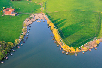Des promenades en bois bordées de cabanes de pêcheurs longent les rives de l'étang du Welschhof. à Puttelange-aux-Lacs dans le département Moselle, France