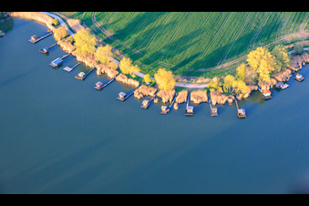 Des promenades en bois bordées de cabanes de pêcheurs longent les rives de l'étang du Welschhof. à Puttelange-aux-Lacs dans le département Moselle, France
