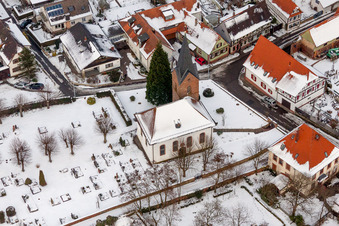 Vue aérienne de Bâtiments d'église et cimetière enneigés en hiver au centre du village à Winden dans le département Rhénanie-Palatinat, Allemagne