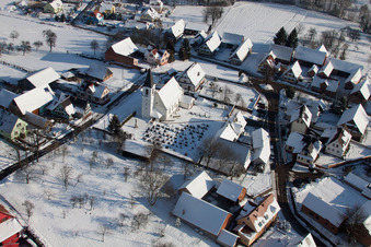 Vue oblique de Bâtiments d'église enneigés en hiver dans le centre du village à Eberbach-Seltz dans le département Bas Rhin, France