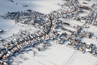 Vue aérienne de Bâtiments d'église enneigés en hiver dans le centre du village à Schleithal dans le département Bas Rhin, France
