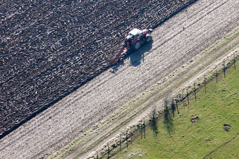 Vue aérienne de Labourage et retournement du sol par un tracteur équipé d'une charrue dans les champs agricoles à Lampertsloch dans le département Bas Rhin, France