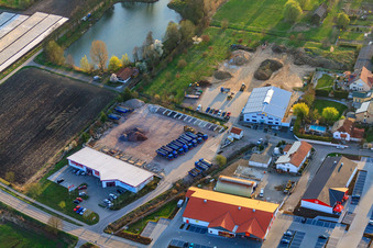 Vue aérienne de Zone commerciale Im Riegel avec Schuh-Hanss au bord de l'étang de l'association de pêche sportive de Herxheim à Herxheim bei Landau dans le département Rhénanie-Palatinat, Allemagne