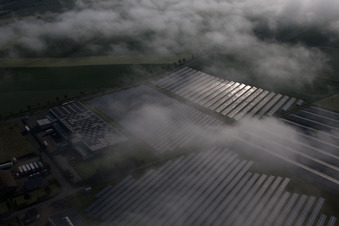 Vue oblique de Rangées de panneaux du système photovoltaïque du parc solaire ou de la centrale solaire noyées dans une couche de brouillard due aux intempéries à le quartier Bredenborn in Marienmünster dans le département Rhénanie du Nord-Westphalie, Allemagne