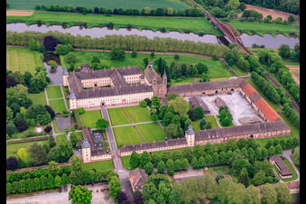 Photographie aérienne de Château de Corvey, site classé au patrimoine mondial de l'UNESCO, sur les rives de la Weser avec restaurant du château, Weser-Aktivhotel-Corvey et Remtergarten State Garden Show Höxter à Höxter dans le département Rhénanie du Nord-Westphalie, Allemagne