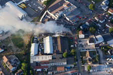 Vue oblique de Formation de fumée et de flammes lors des travaux d'extinction d'un grand incendie dans un entrepôt d'antiquités et de vieilles voitures sur la Werkstrasse à Speyer dans le département Rhénanie-Palatinat, Allemagne
