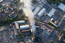 Formation de fumée et de flammes lors des travaux d'extinction d'un grand incendie dans un entrepôt d'antiquités et de vieilles voitures sur la Werkstrasse à Speyer dans le département Rhénanie-Palatinat, Allemagne hors des airs