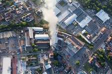 Fumée et flammes lors des opérations d'extinction d'un grand incendie dans un entrepôt avec des antiquités et de vieilles voitures dans la Werkstrasse à Speyer dans le département Rhénanie-Palatinat, Allemagne depuis l'avion