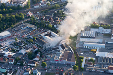 Enregistrement par drone de Fumée et flammes lors des opérations d'extinction d'un grand incendie dans un entrepôt avec des antiquités et de vieilles voitures dans la Werkstrasse à Speyer dans le département Rhénanie-Palatinat, Allemagne
