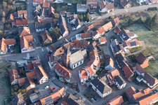 Église fortifiée luthérienne-protestante entourée d'un anneau de maisons au centre du village à Dossenheim-sur-Zinsel dans le département Bas Rhin, France du point de vue du drone