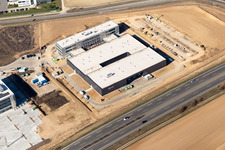 Vue aérienne de Nouveau bâtiment - chantier de construction des bâtiments et des halls de production de l'usine Eizo GmbH dans la zone industrielle nord à Rülzheim dans le département Rhénanie-Palatinat, Allemagne