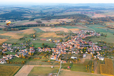 Vue aérienne de Les terres agricoles et les limites des champs entourent la zone d'implantation du village avec des montgolfières à Kindwiller dans le département Bas Rhin, France