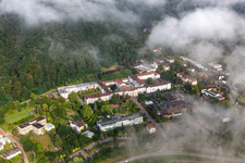 Des nuages denses au-dessus de l’hôpital palatin de psychiatrie et de neurologie à Klingenmünster dans le département Rhénanie-Palatinat, Allemagne d'en haut
