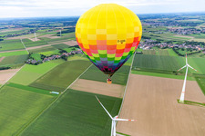 Vue oblique de Une montgolfière vole près de l'éolienne à le quartier Straeten in Heinsberg dans le département Rhénanie du Nord-Westphalie, Allemagne