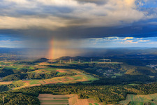 Photographie aérienne de Parc éolien Merchingen devant un mur de pluie avec arc-en-ciel à le quartier Merchingen in Merzig dans le département Sarre, Allemagne