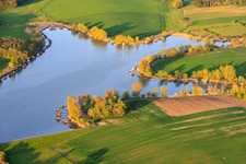 Des promenades en bois bordées de cabanes de pêcheurs longent les rives de l'étang du Welschhof. à Puttelange-aux-Lacs dans le département Moselle, France